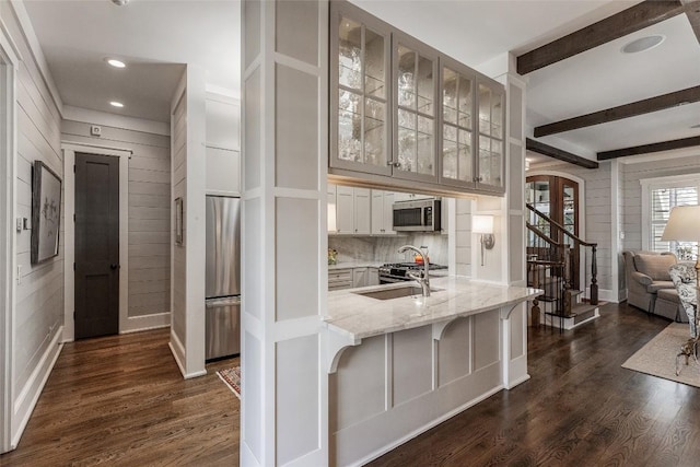 kitchen featuring sink, dark wood-type flooring, a breakfast bar area, stainless steel appliances, and white cabinets