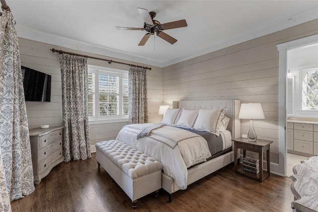 bedroom with dark wood-type flooring, ceiling fan, and wooden walls