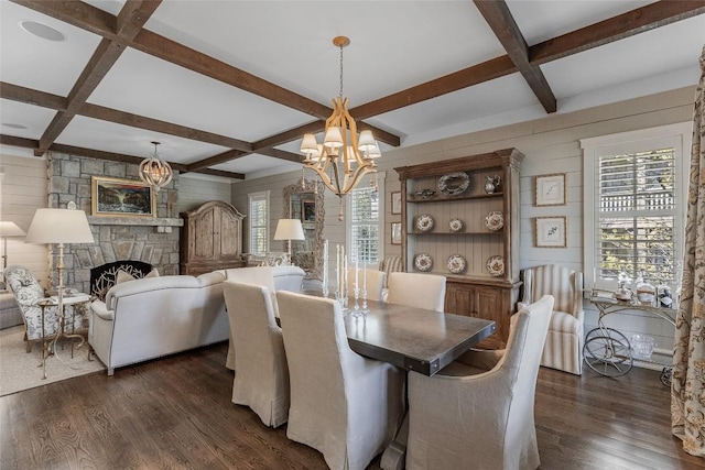 dining area with coffered ceiling, a fireplace, dark wood-type flooring, and an inviting chandelier