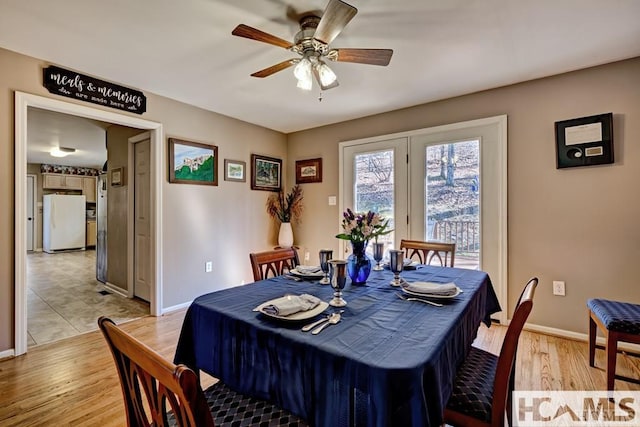 dining area featuring baseboards, light wood-type flooring, and a ceiling fan