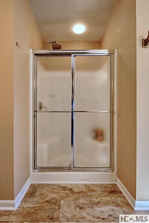 full bath featuring baseboards and a shower stall
