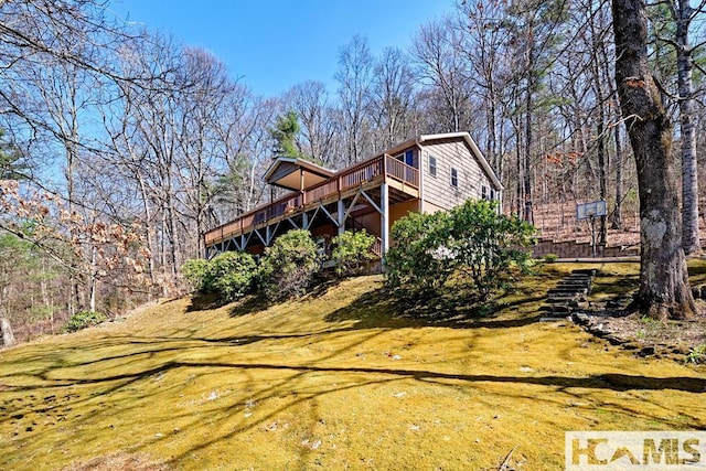 view of property exterior featuring a yard and a deck