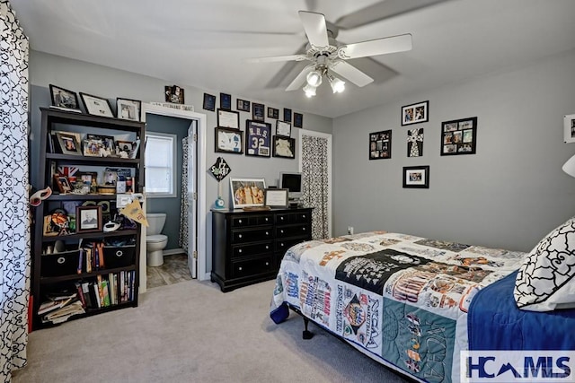 carpeted bedroom with ensuite bath and a ceiling fan