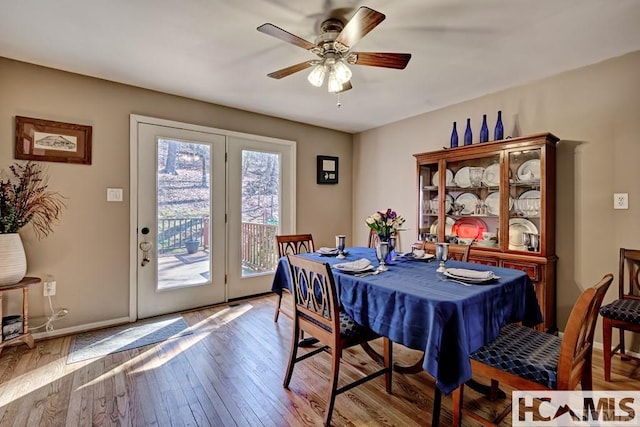 dining room featuring wood-type flooring, ceiling fan, and baseboards