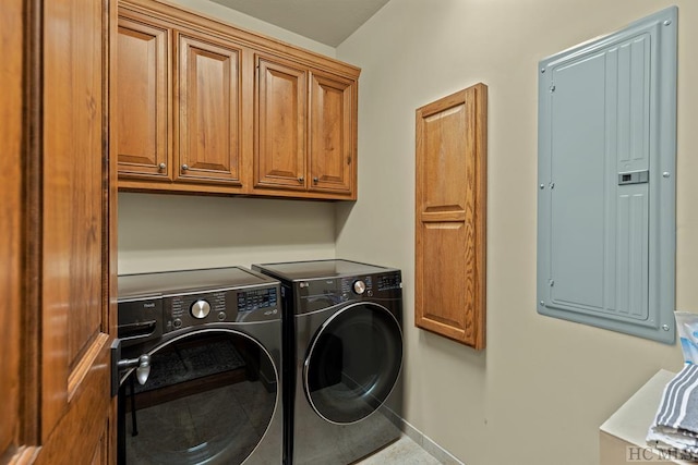 clothes washing area with electric panel, washer and clothes dryer, and cabinets