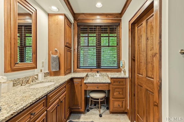 bathroom with ornamental molding, vanity, and a wealth of natural light