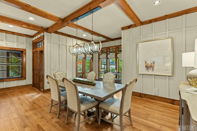 dining space featuring beamed ceiling, a chandelier, and light hardwood / wood-style floors