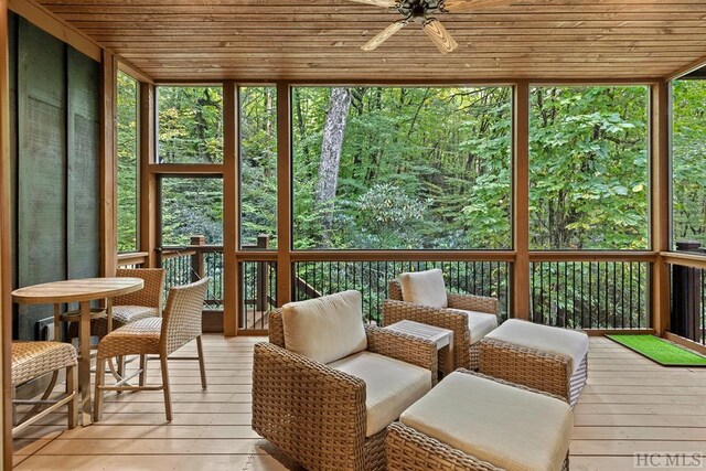 sunroom featuring a healthy amount of sunlight, wooden ceiling, and ceiling fan