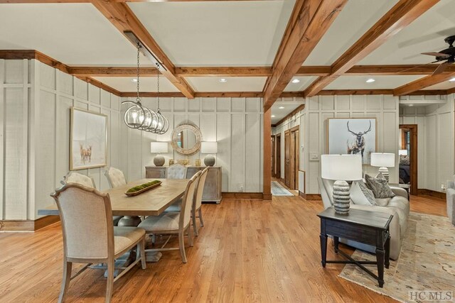 dining area featuring ceiling fan, light wood-type flooring, coffered ceiling, and beam ceiling