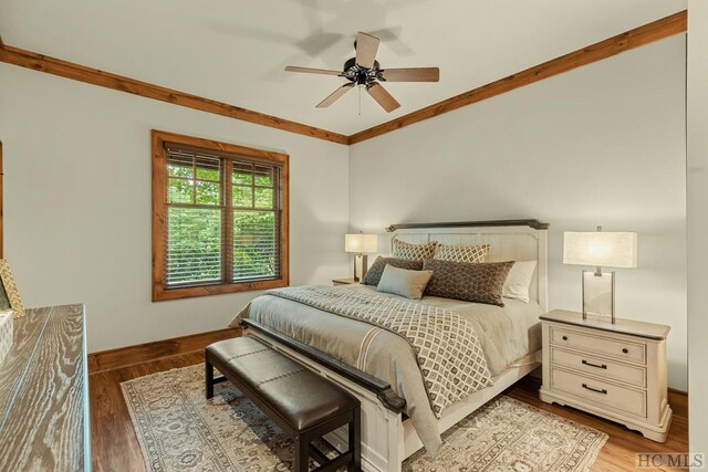 bedroom featuring dark hardwood / wood-style flooring, crown molding, and ceiling fan