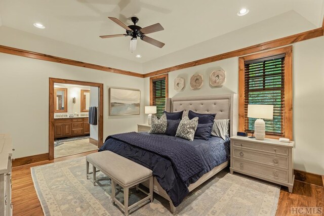 bedroom featuring ceiling fan, light hardwood / wood-style floors, and ensuite bath