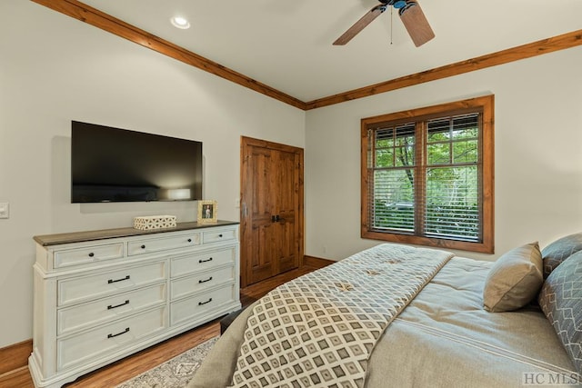 bedroom with ceiling fan, ornamental molding, and hardwood / wood-style floors