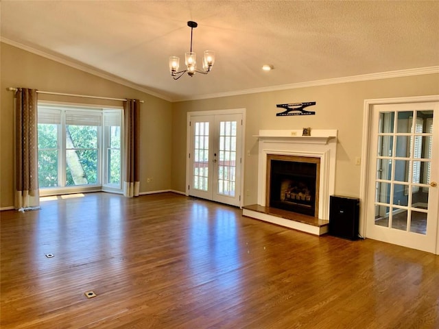 unfurnished living room with a fireplace with raised hearth, crown molding, vaulted ceiling, french doors, and wood finished floors