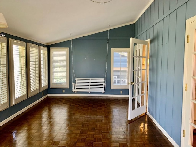 spare room featuring vaulted ceiling and baseboards