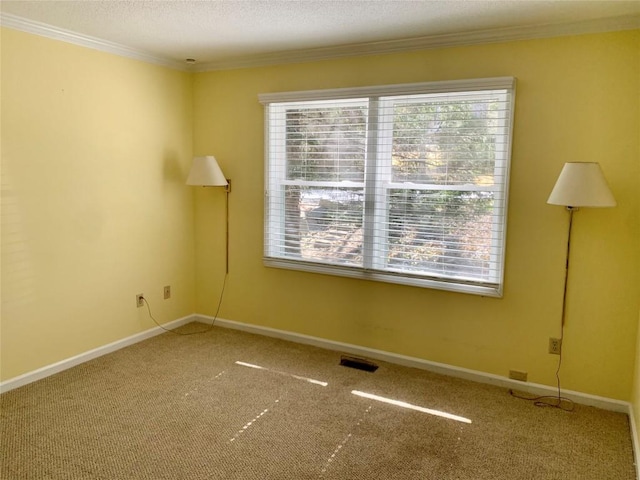 spare room with visible vents, baseboards, and crown molding