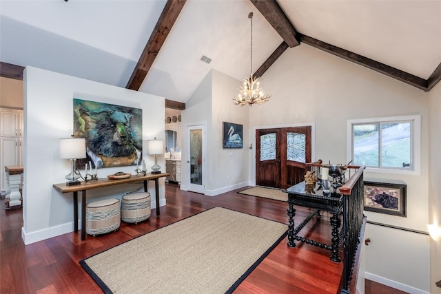 entrance foyer with a chandelier, wood finished floors, visible vents, baseboards, and beam ceiling