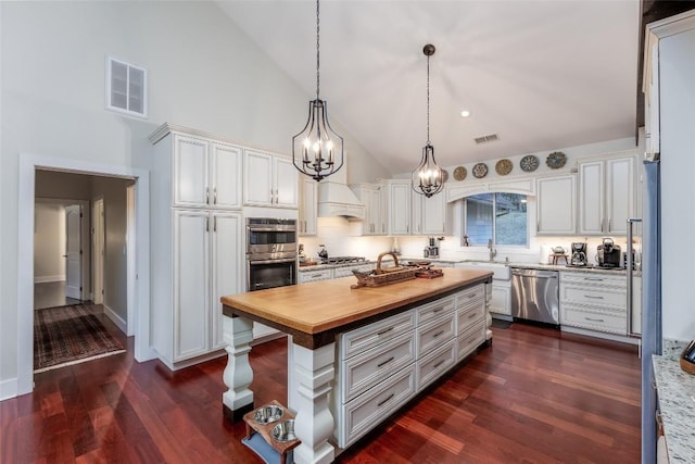 kitchen featuring white cabinetry, visible vents, butcher block countertops, and appliances with stainless steel finishes