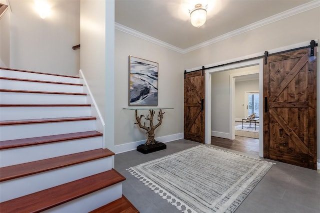 entrance foyer featuring baseboards, a barn door, stairway, and crown molding