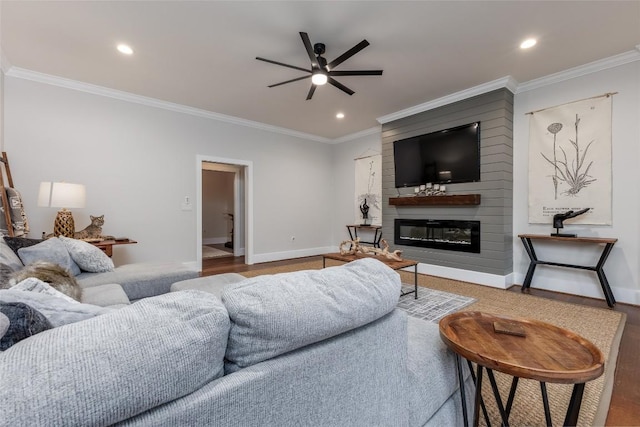 living area featuring baseboards, ceiling fan, a fireplace, and crown molding