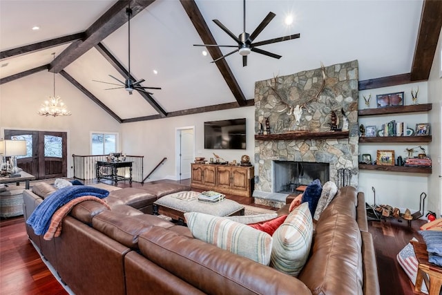 living area with wood finished floors, a stone fireplace, high vaulted ceiling, beam ceiling, and ceiling fan with notable chandelier
