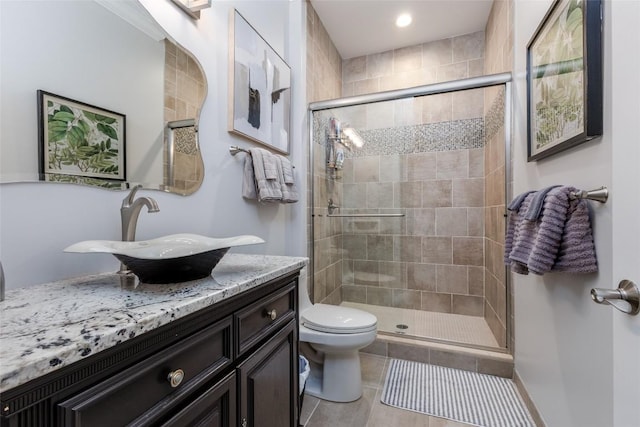 full bath featuring a stall shower, tile patterned flooring, vanity, and toilet