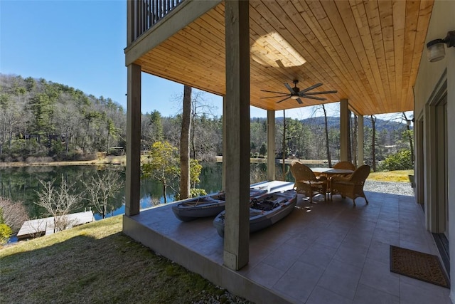 view of patio featuring outdoor dining area, a water view, and a ceiling fan