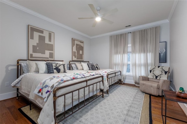 bedroom with baseboards, visible vents, ceiling fan, ornamental molding, and wood finished floors