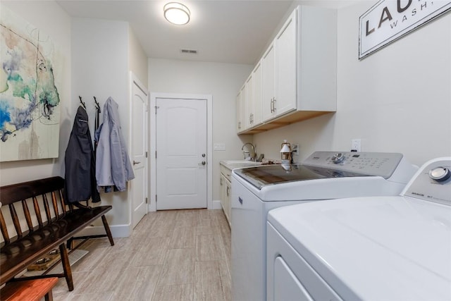 laundry room featuring a sink, visible vents, baseboards, cabinet space, and washing machine and clothes dryer