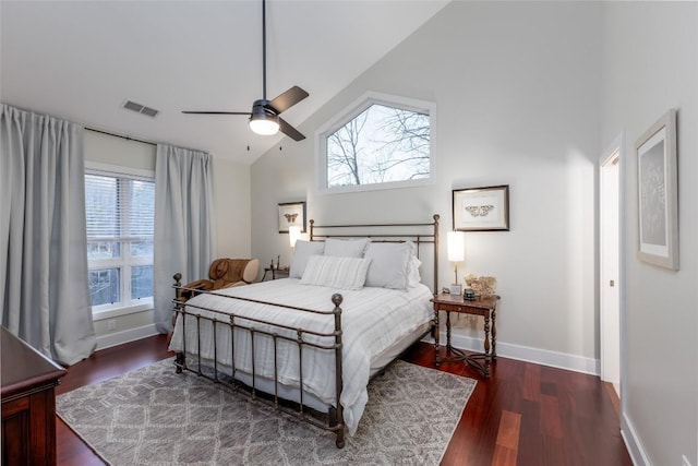 bedroom with high vaulted ceiling, wood finished floors, a ceiling fan, visible vents, and baseboards