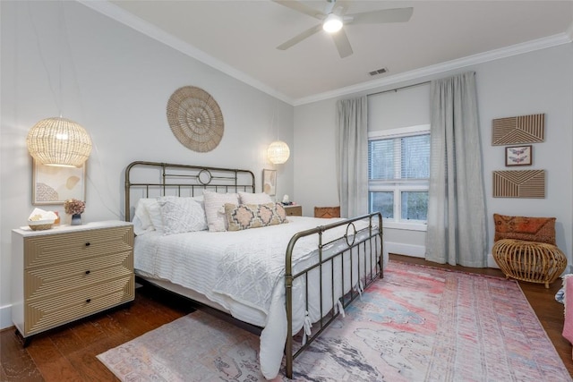 bedroom with crown molding, visible vents, ceiling fan, and wood finished floors