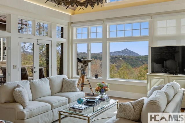 sunroom / solarium with healthy amount of natural light, a mountain view, and french doors