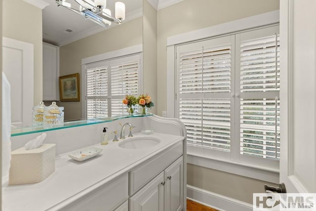 bathroom featuring ornamental molding, vanity, plenty of natural light, and a chandelier