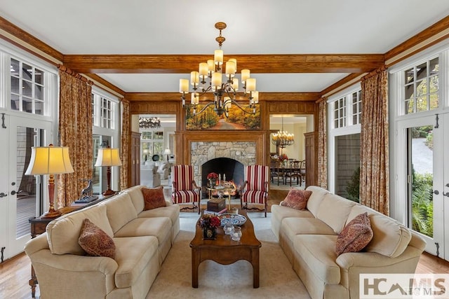 living area featuring a chandelier, beam ceiling, and light wood-style floors