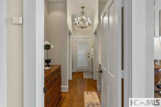 doorway to outside featuring a chandelier and wood finished floors