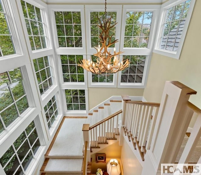 stairway featuring a chandelier and a towering ceiling