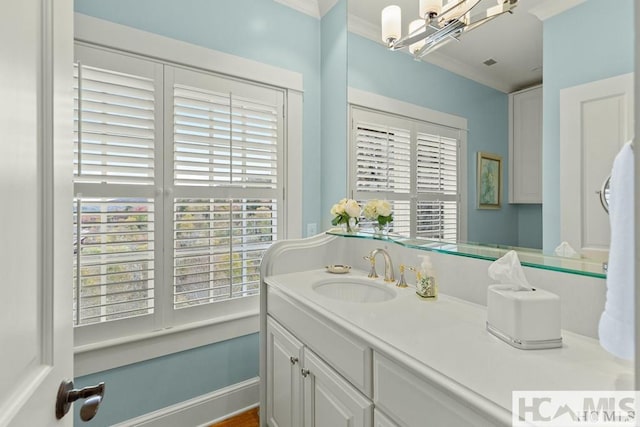 bathroom featuring ornamental molding, a chandelier, and vanity
