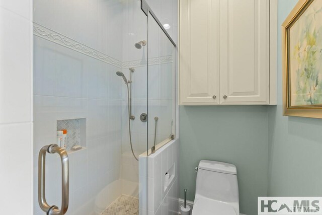 full bathroom with a tile shower and toilet