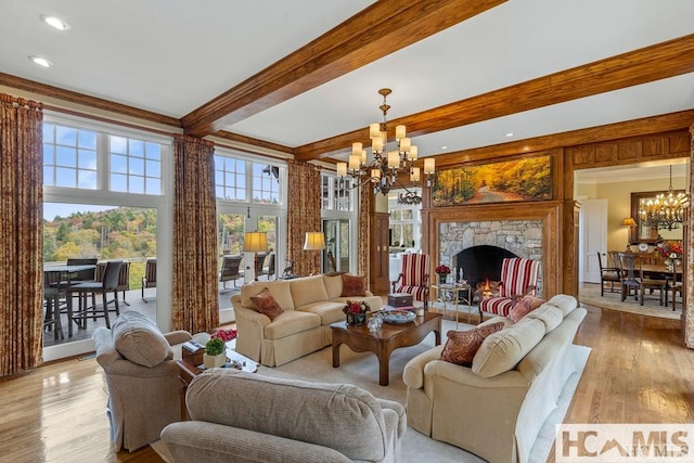living area featuring a chandelier, beamed ceiling, light wood finished floors, a fireplace, and recessed lighting