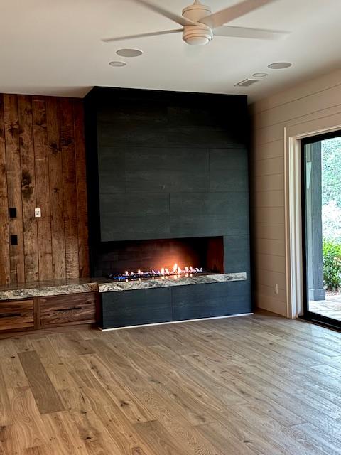 34 Crescent Trl, Highlands, NC 28741 - detailed view of wooden walls, wood finished floors, a fireplace, and a ceiling fan