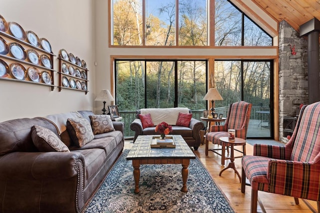 living area featuring high vaulted ceiling and light wood-style flooring