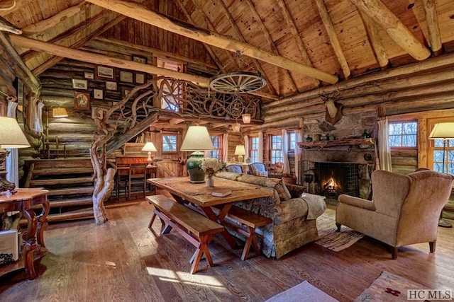 dining area featuring beam ceiling, wood ceiling, log walls, and hardwood / wood-style flooring