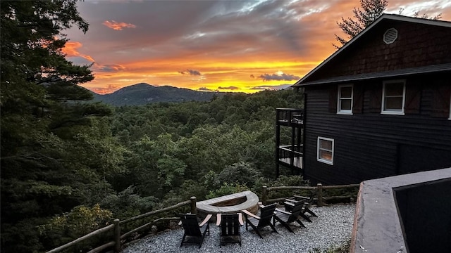 665 Trays Island Rd, Sapphire, NC 28774 - property exterior at dusk with a fire pit, a view of trees, a balcony, and a mountain view