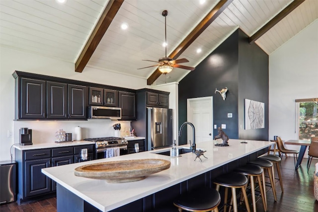 665 Trays Island Rd, Sapphire, NC 28774 - kitchen with stainless steel appliances, a sink, a breakfast bar area, light countertops, and dark wood-style floors
