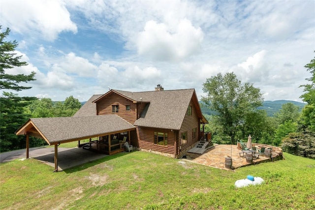 267 Hero Ln, Glenville, NC 28736 - back of house with roof with shingles, a yard, a carport, a chimney, and a patio area