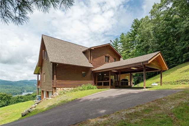 267 Hero Ln, Glenville, NC 28736 - log-style house featuring log exterior, driveway, a shingled roof, a carport, and a front lawn