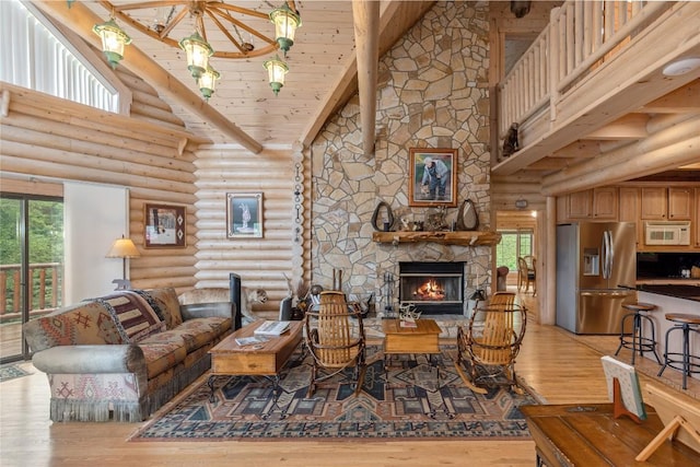 267 Hero Ln, Glenville, NC 28736 - living area with high vaulted ceiling, log walls, light wood-type flooring, a stone fireplace, and healthy amount of natural light