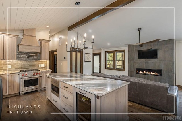 kitchen with lofted ceiling with beams, decorative backsplash, a center island, stainless steel appliances, and custom range hood