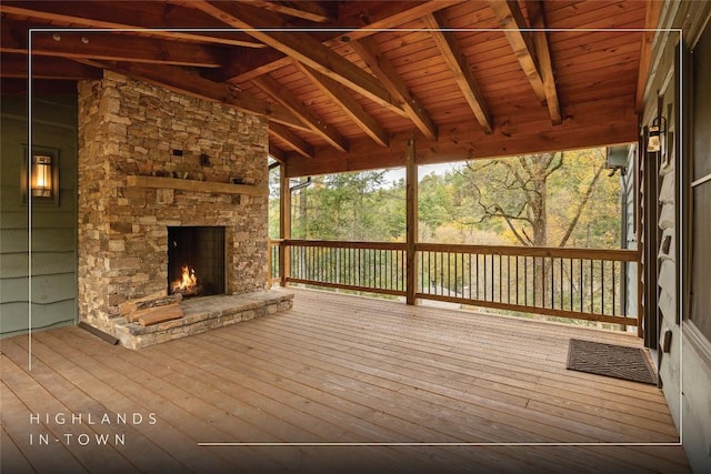 wooden terrace featuring an outdoor stone fireplace