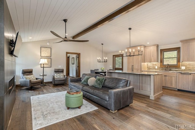 living room featuring lofted ceiling with beams, a wealth of natural light, sink, and hardwood / wood-style floors