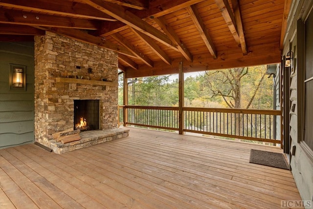 wooden terrace featuring an outdoor stone fireplace